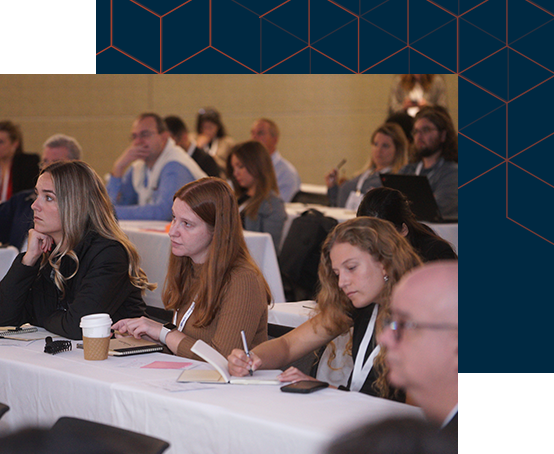 Attendees seated at tables in a conference room, actively involved in a collaborative meeting or conference session 